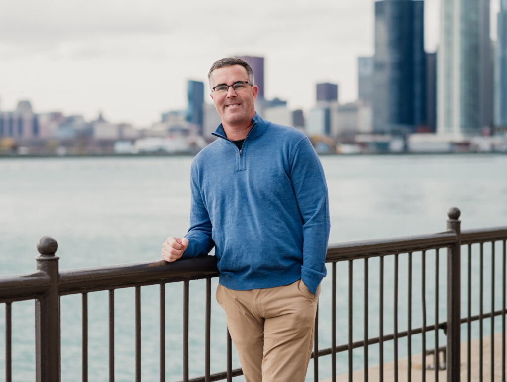 man leaning against a railing overlooking the city
